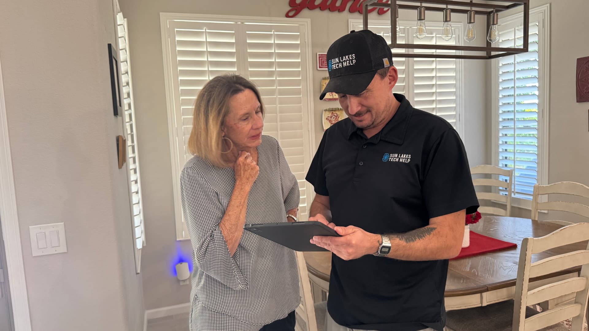 A SilverShield concierge reviewing a tablet with a client in her home