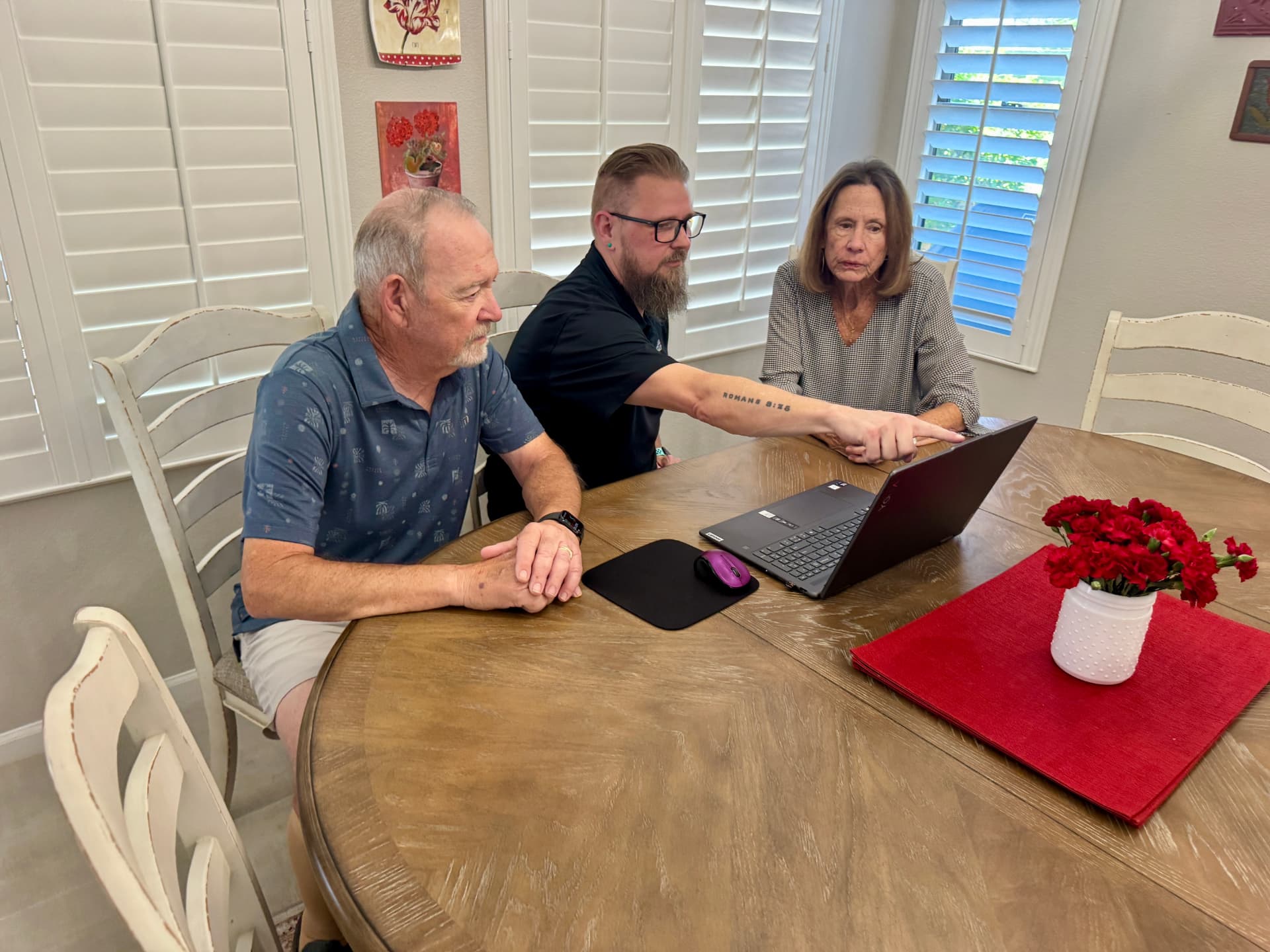 A SilverShield concierge guiding two neighbors through a laptop screen