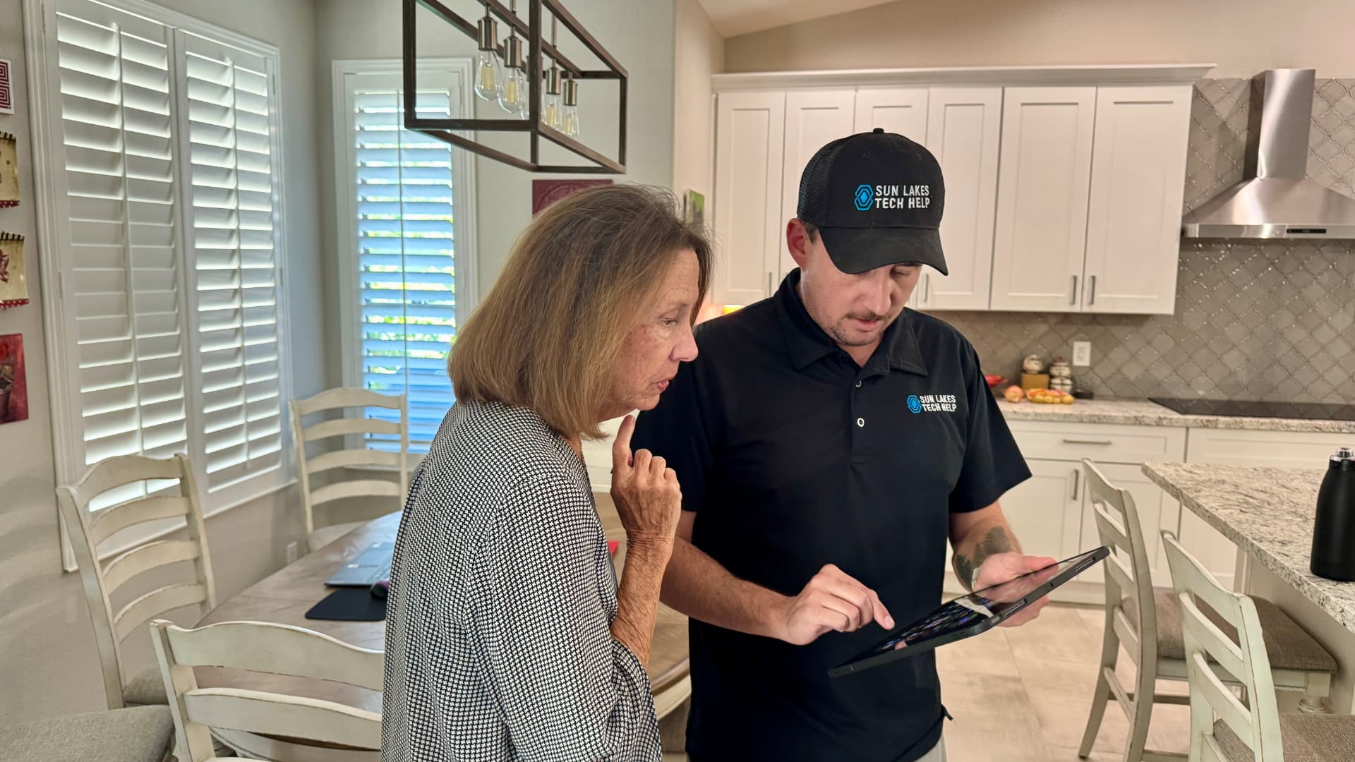 A SilverShield technician showing a tablet to a client in her home